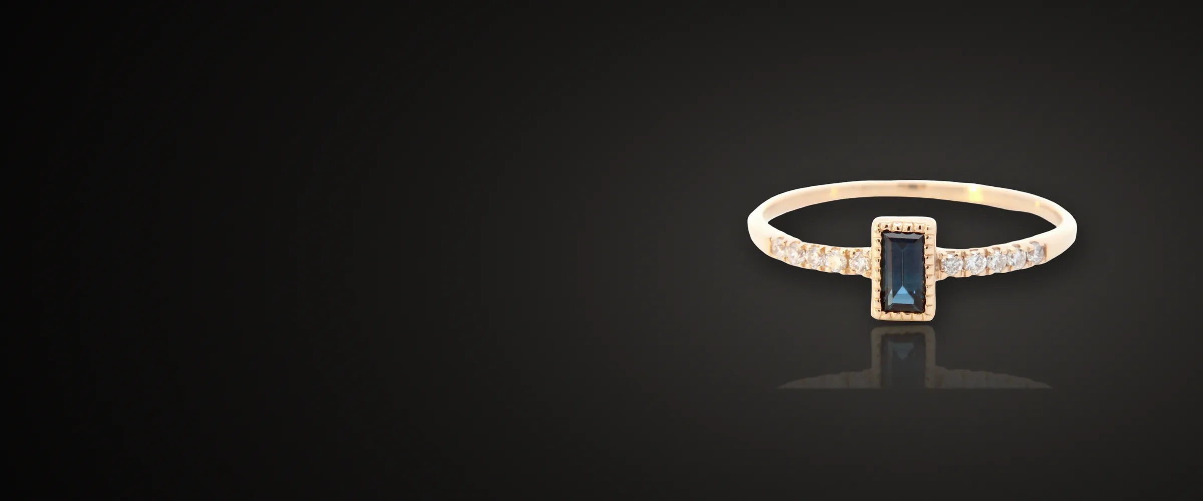 Yellow gold ring with a baguette sapphire and a diamond band