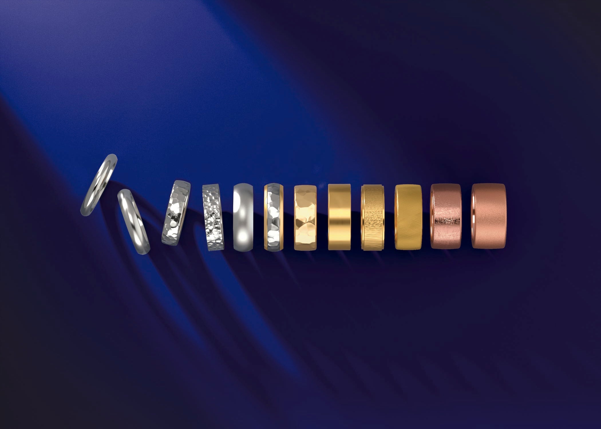 Stack of different gold rings, white, yellow, rose in color and textured with different finishes. 